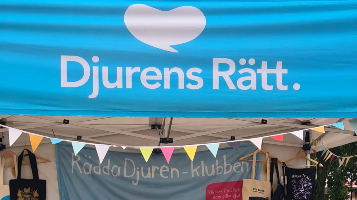 Ett tält från Djurskyddsorganisationen Djurens Rätt med färgglada vimplar och en skylt för Rädda Djuren-klubben.