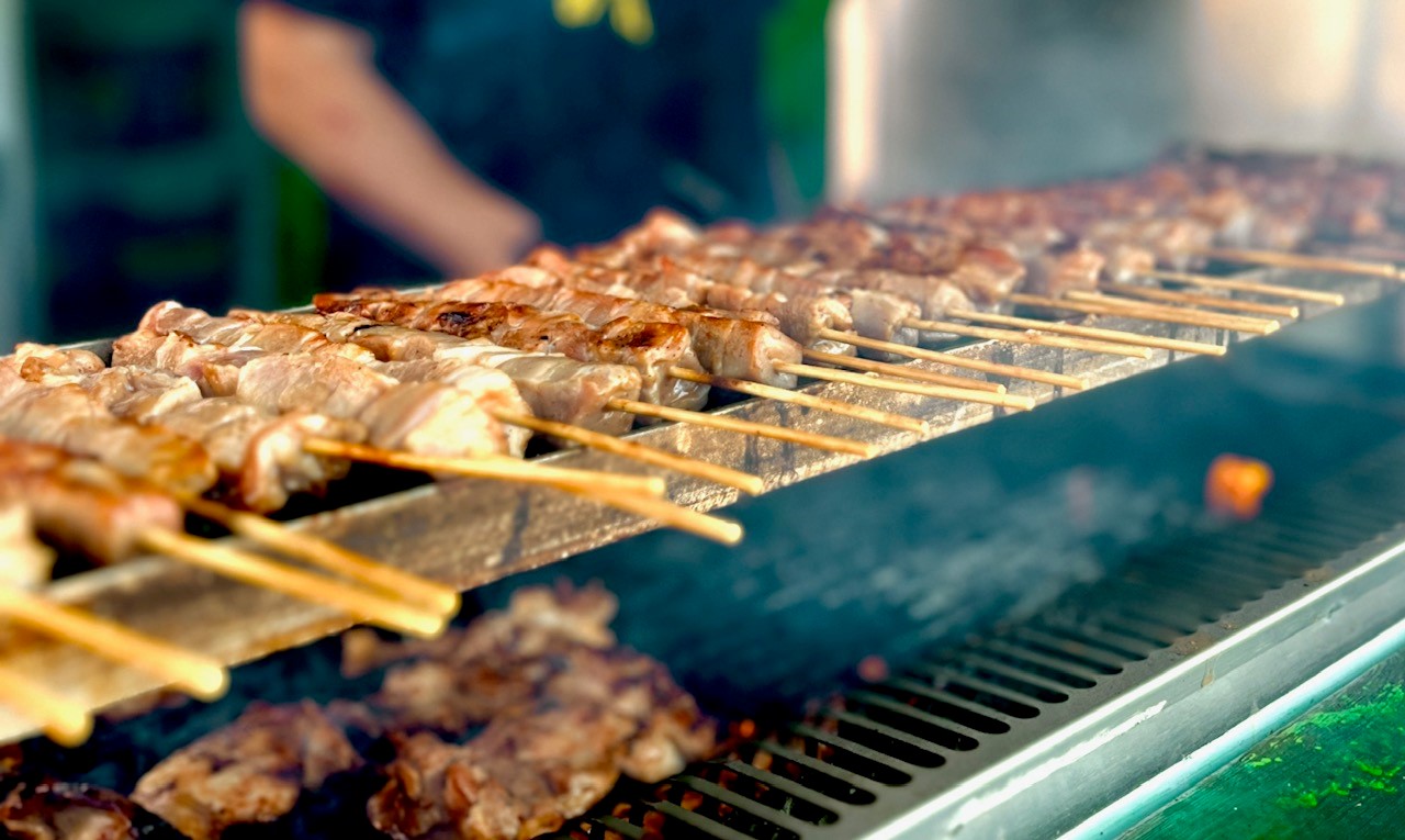 Grillspett på en grill med glöd.